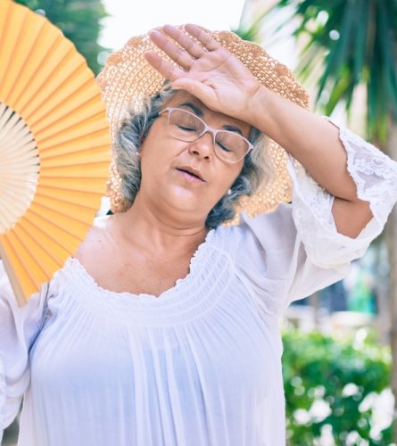 Schwitzende Frau an heißem Sommertag