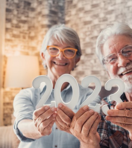 Portrait of couple of two old pensioners holding together number